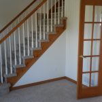 Interior view featuring a wooden staircase with white balusters and a wooden handrail