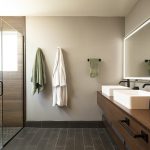A double vanity with two rectangular vessel sinks and dark-colored faucets