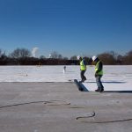 workers installing roll roofing