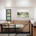 A modern home interior featuring a loft or upper-level landing with a view down a staircase