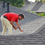 worker inspecting roof tiles