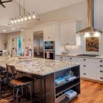large kitchen with a spacious island, granite countertops, and appliances