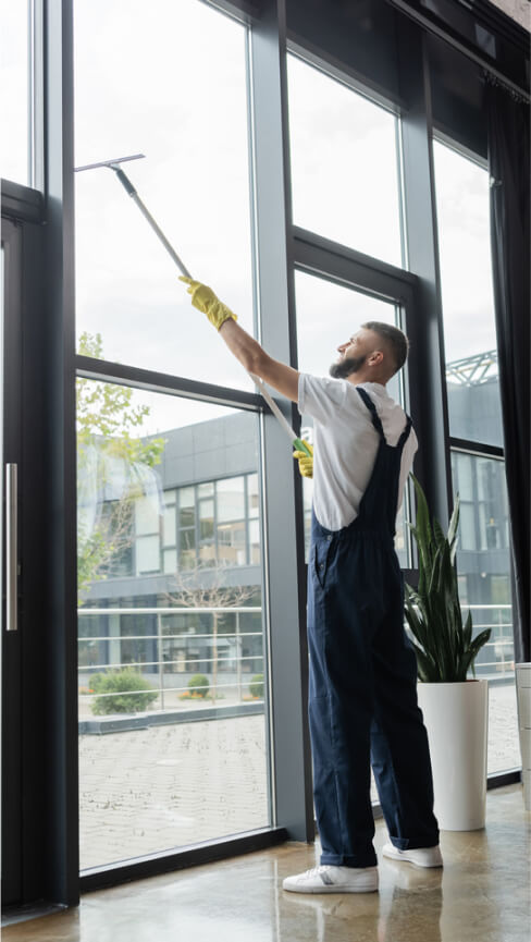 full-length-man-overalls-washing-windows-office-