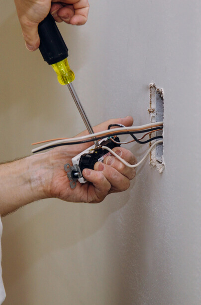 Electrician installing electrical socket on a wall