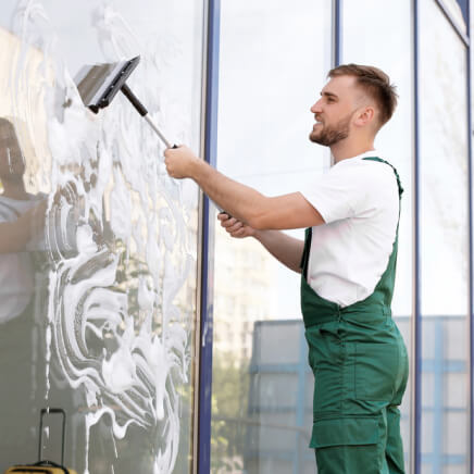 male-cleaner-wiping-window-glass-squeege