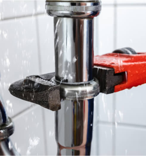 Closeup of wrench on a leaking pipe 