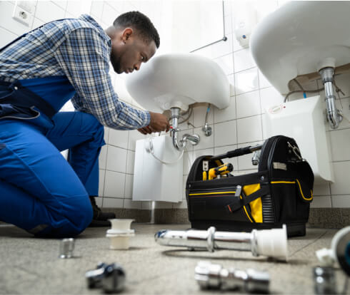 Plumber working on a broken bathroom sink