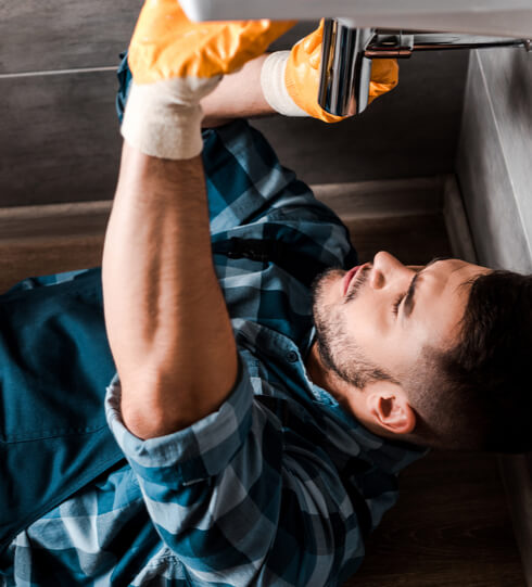 Plumber carefully fixing the bathroom sink