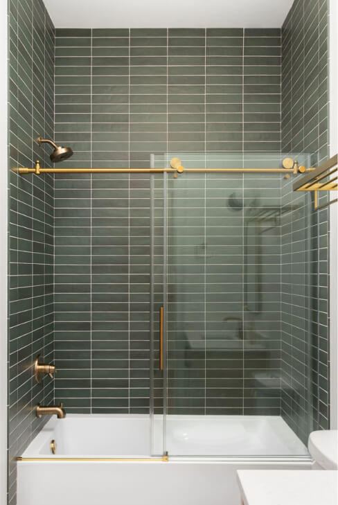 shower-green-subway-tiles-gold-faucet-accents-white-bathtub