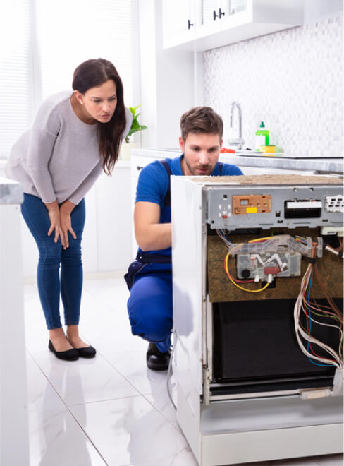 img - smiling-woman-technician-repairing-dishwasher-kitchen