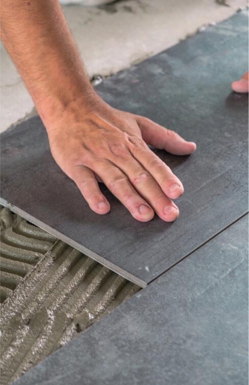 img - worker-placing-ceramic-floor-tiles-adhesive-surface