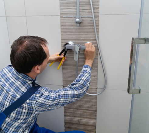 Bathroom Remodeling worker fixing shower faucet