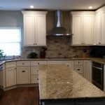 a kitchen featuring granite countertops and white cabinetry
