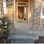 concrete walkway leading to entrance door of a home