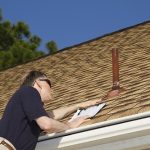 worker checking on a document placed on top of a roof