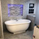 A modern bathroom featuring a freestanding oval bathtub