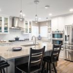 modern kitchen design with black chairs surrounding bar
