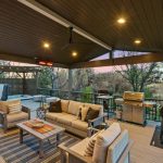 covered deck with sofa, grillers, and tub in the corner