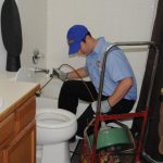 technician performing a plumbing repair in the bathroom