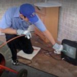 Technician performing a drain cleaning or sewer line inspection service
