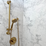 brass-toned shower fixture with a handheld showerhead and a coordinating control valve